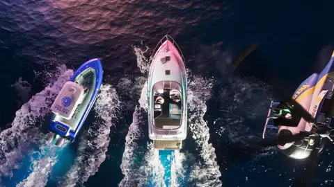 an aerial view of three speedboats cutting white wakes across dark water in a Rockstar Games image for GTA 6