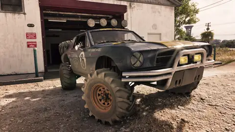 a black lifted off road buggy with roof lights parked outside a white garage on a dusty lot in a Rockstar Games image for GTA 6
