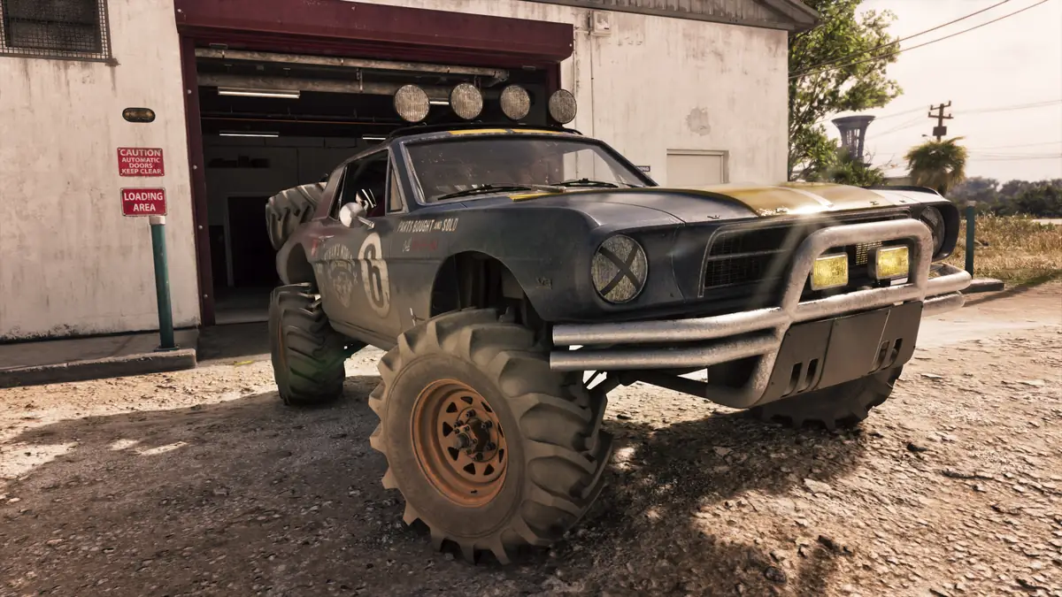 a black lifted off road buggy with roof lights parked outside a white garage on a dusty lot in a Rockstar Games image for GTA 6