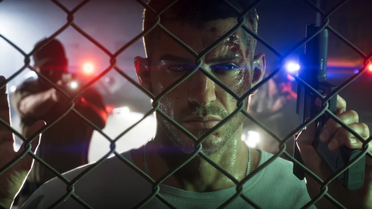 Jason behind a chain link fence lit by red and blue police lights at night in a Rockstar Games screenshot for GTA 6