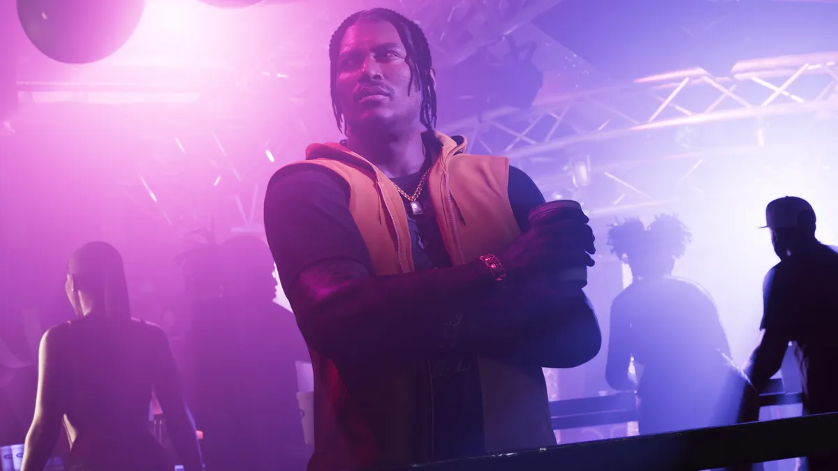 DreQuan Priest with his arms folded above a crowded purple lit nightclub in a Rockstar Games screenshot for GTA 6