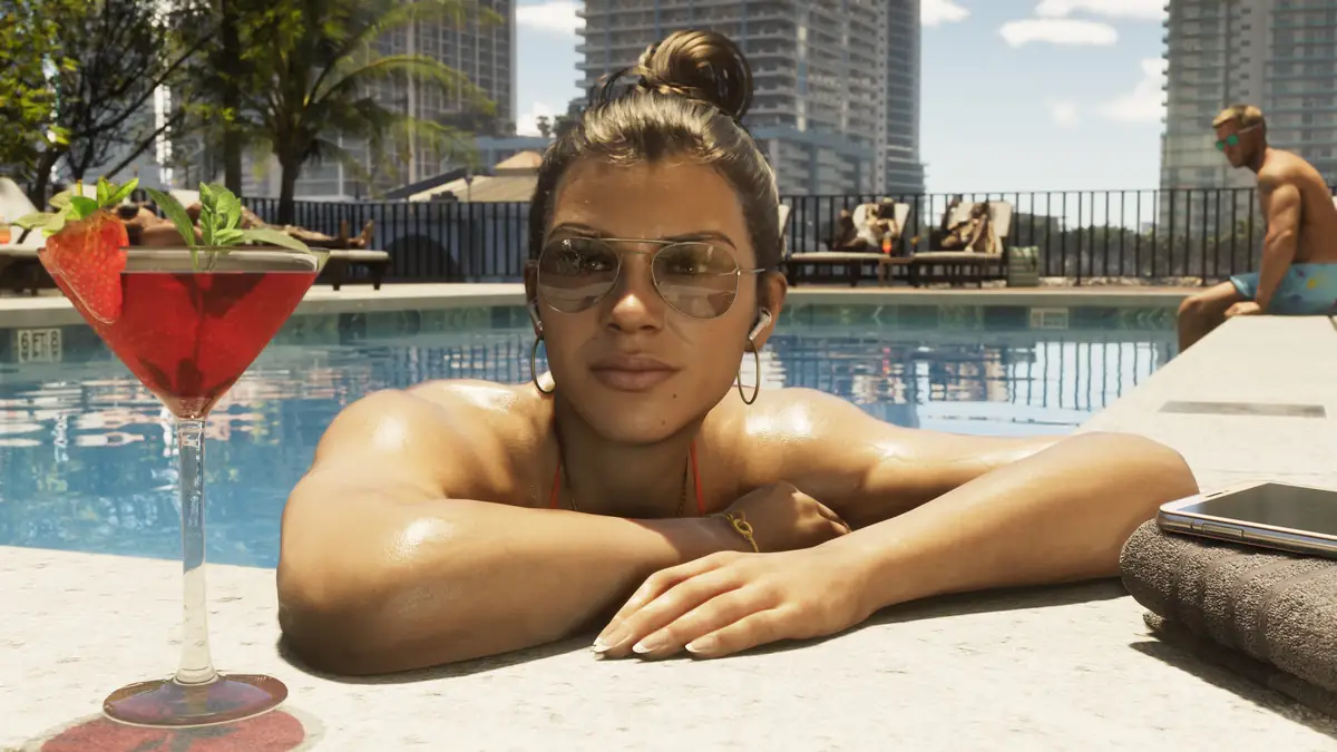 Lucia resting her arms on the edge of a rooftop pool beside a red cocktail with towers behind her in a Rockstar Games screenshot for GTA 6