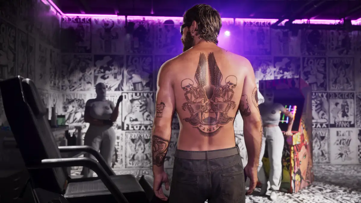 a tattooed man standing in a tattoo parlour lit by purple neon in a Rockstar Games image for GTA 6