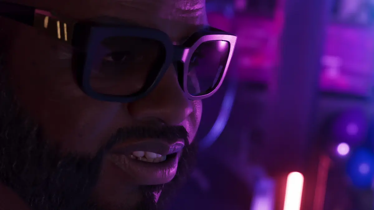 a bearded man in black glasses lit by purple club lights in an official GTA 6 screenshot